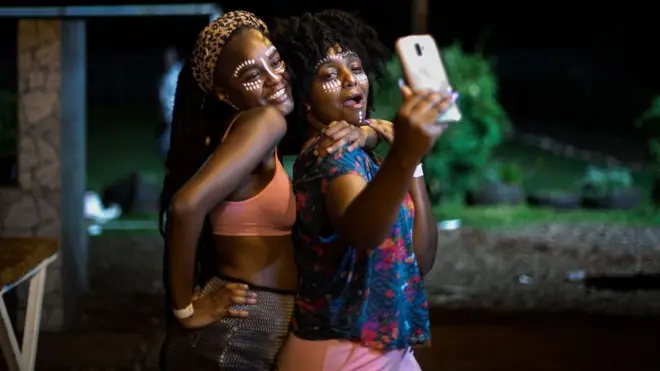 Des personnes prennent un selfie lors d'une fête à Nairobi, au Kenya, le 4 octobre 2020, lors du premier week-end après que le président kényan Uhuru Kenyatta a annoncé le changement de l'heure du couvre-feu à 23 heures et que la vente d'alcool a été autorisée dans les clubs et les fêtes.