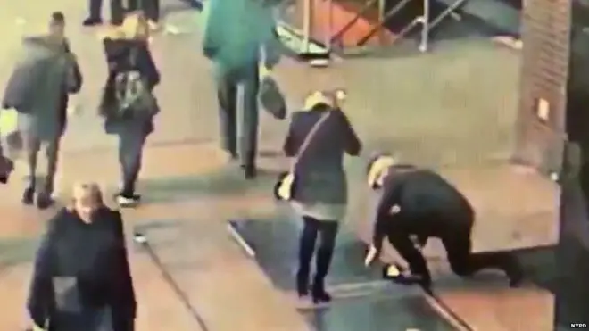 A man trying to retrieve a ring from a grate