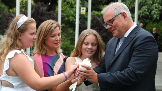 Scott Morrison and his wife and two daughters hold a bird