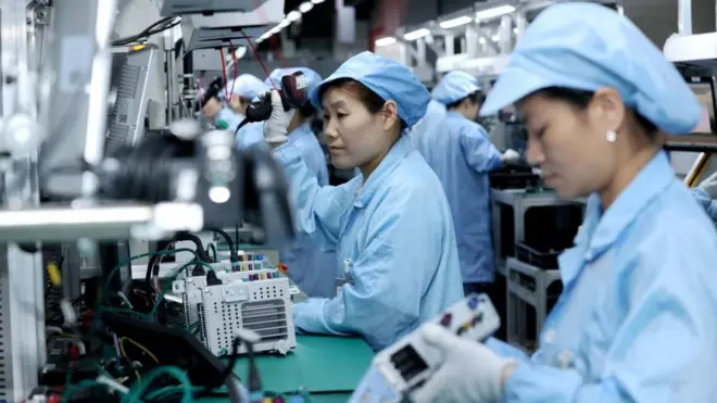 Workers work on a production line manufacturing smart automotive central control navigation products at a factory of Beidou Intelligent Connected Vehicle Technology Co. (BICV) in the High Tech Industrial Development Zone in Suqian, Jiangsu Province, China