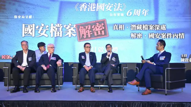 2026年6月29日,香港保安局就電視節目《國安檔案解密》舉行啟播禮。圖中人士包括保安局局長鄧炳強、懲教署懲教事務監督林賜良、法學教授江樂士資深大律師、香港警務處國家安全處總警司李桂華、節目主持人陳啟泰。