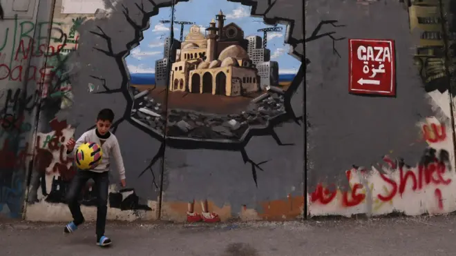 Палестинский мальчик у стены с граффити, на котором изображена будущая реконструкция Газы