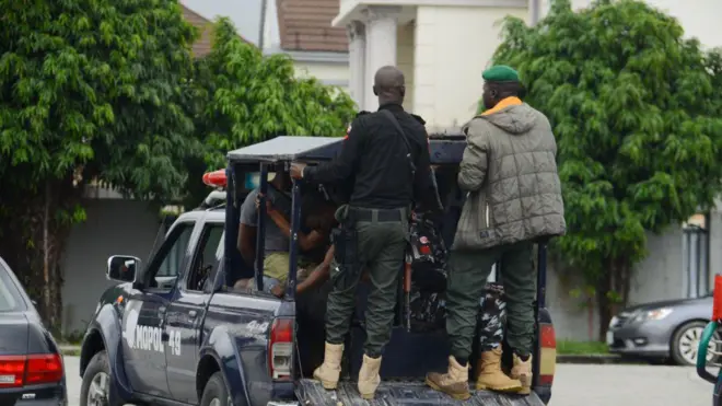 Awon olopaa meji naro mọ ọkọ wọn to n lọ, awọn kan jokoo sinu ọkọ naa.