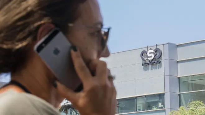 Umugore wo muri Israel ari gukoresha iPhone imbere y'ibiro bikuru by'ikigo NSO group, i Herzliya, hafi ya Tel Aviv mu 2016