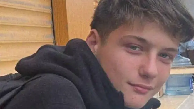Atlas Çağlayan'ın yakın plan fotoğrafı. Mavi gözlü genç kameraya bakıyor. Siyah bir kapüşonlu hırka giymiş.