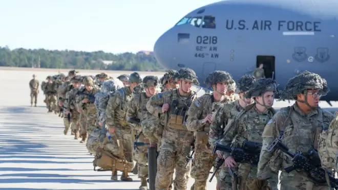 قوات أمريكية وفي الخلفية طائرة مكتوب عليها سلاح الجو الامريكي.