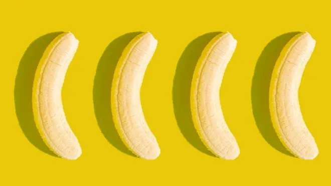 Sarı bir arka plan üzerinde yan yana dizilmiş, kabukları soyulmuş dört muz.