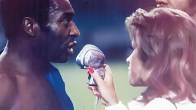 Mulher entrevista Pelé em campo de futebol