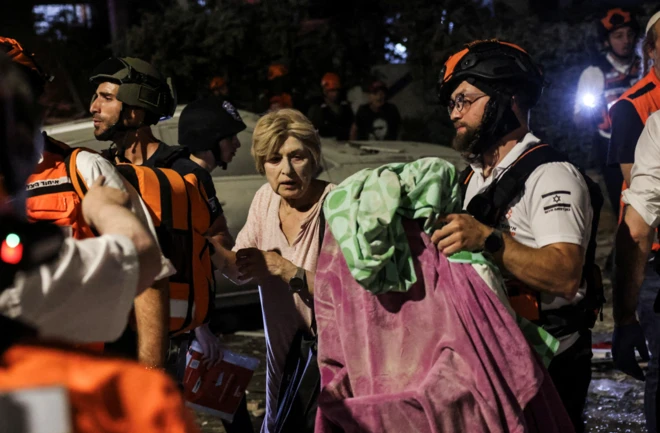 이스라엘 구조대가 이란의 미사일 공격으로 부상을 입을 여성을 구조하고 있다