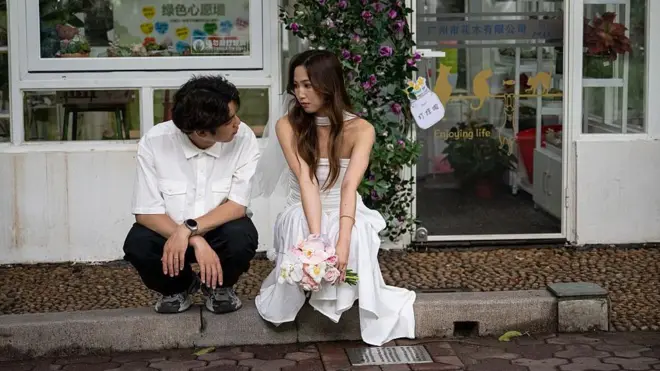 Casal no lado de fora do Registro Civil em Guangzhou, na província chinesa de Guangdong, no dia 20 de maio de 2025