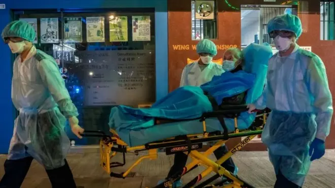 Paramedics wearing personal protective equipment carry patient on a stretcher in North Point district on February 23, 2020 in Hong Kong, China.
