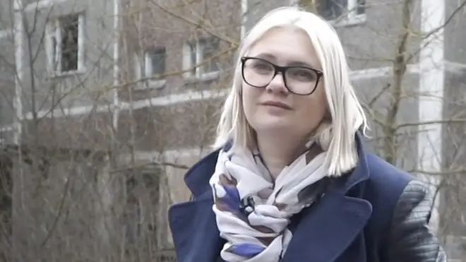 柳德米拉·洪查站在乌克兰普里皮亚特旧居前