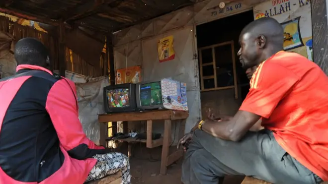 People dey watch di 2013 Africa Cup of Nations football wey dey between Mali and Ghana for TV set top