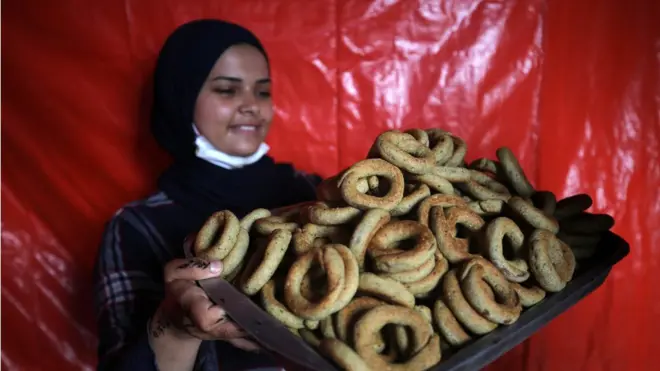 فتاة غزية من دير البلح متطوعة ضمن مبادرة لصنع كعك العيد وتوزيعه على الأسر رغم الحرب