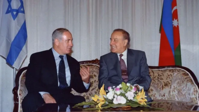 نتانیاهو روی مبلی کنار حیدر علی اف نشسته است در حال گفت‌وگو هستند