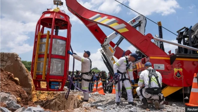 Rescue workers use a special cage to drag South African miners - both dead and alive - to the surface.