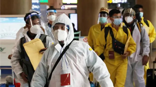 29일 인천국제공항 제1여객터미널에 방호복과 페이스 쉴드를 착용한 해외 입국자들이 이동하고 있다.