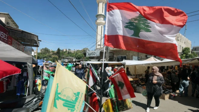 أشخاص يسيرون في شارع في لبنان وعلم لبناني.