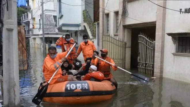 एनडीआरएफ़ की टीम लोगों को सुरक्षित जगहों पर ले जाती हुई