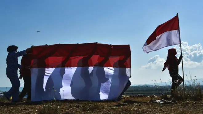 Sejumlah orang mengusung bendera Indonesia untuk memperingati hari ulang tahun kemerdekaan Indonesia di Banda Aceh pada Minggu (16/08) lalu.