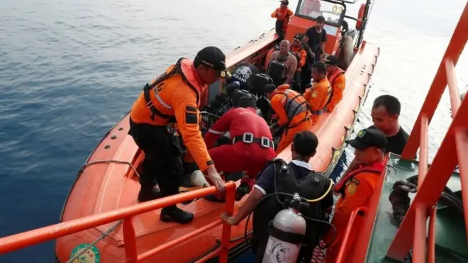 Divers board a small boat off Jakarta