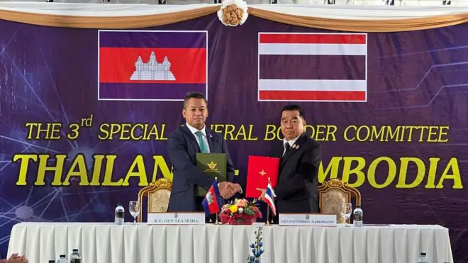 Kamboçya ve Tayland Savunma Bakanları bir masada el sıkışıyor.