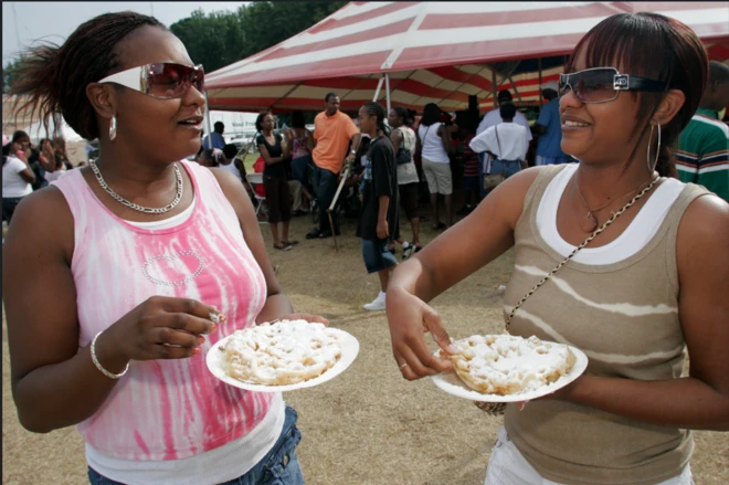 Àwọn obìnrin méjì tí wọ́n gbé abọ́ oúnjẹ dání 