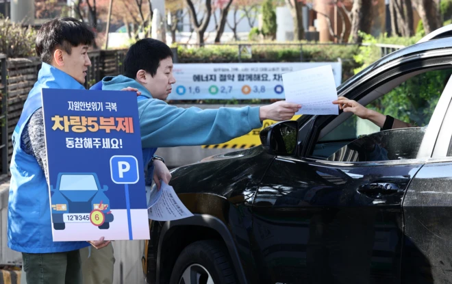 공영주차장 차량 5부제가 시행된 8일 오전 서울 종로구 세종로공영주차장에서 서울시설공단 관계자들이 주차장 이용자들에게 안내문을 배부하며 5부제 참여를 독려하고 있다. 