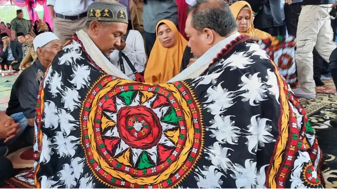 Ritual 'tepung tawar' dilakukan oleh eks Panglima GAM wilayah Linge, Fauzan Azima (kanan) dengan mantan Kepala Desa Pondok Kresek Sutrisno (kiri).
