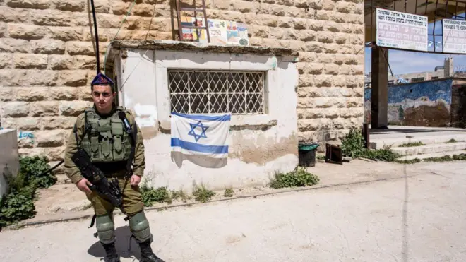 جندي إسرائيلي يحرس مدخل مستوطنة يهودية في الخليل بالضفة الغربية 