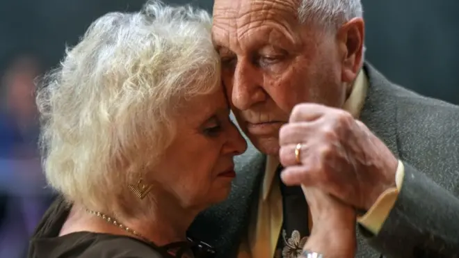 Señores mayores bailando tango.