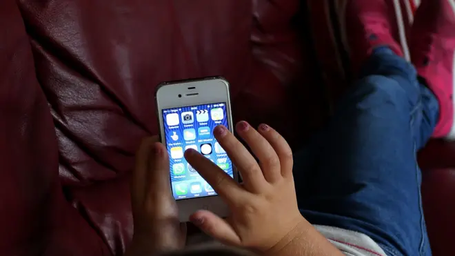 Dete i telefon, dete rukom pretražuje telefon, dete rukom traži aplikacije na telefonu