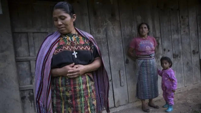 Catarina Mejía (izq.) e Isabel Torres, frente al taller, que lleva años abandonado, de la aldea donde se guardan los repuestos y las piezas para dar mantenimiento a los paneles fotovoltaicos.