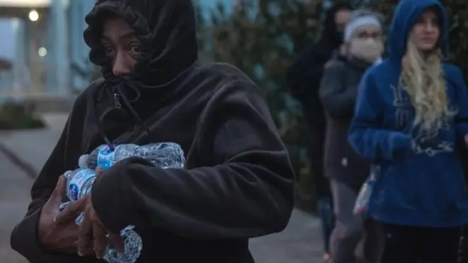 أشخاص يجمعون المياه المعبأة في زجاجات من ملجأ في مدينة غالفيستون، تكساس