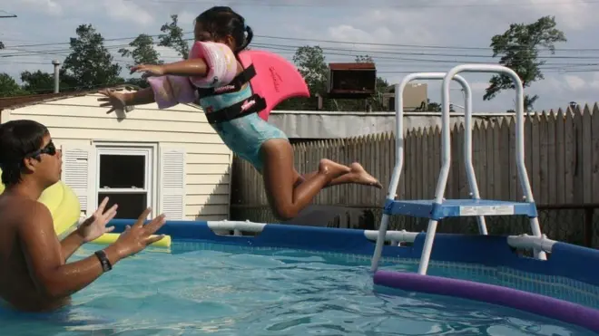 Dos hermanos que aprenden a nadar juntos.