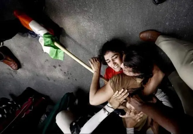 हाथ में तिरंगा लिए ज़मीन पर गिरी महिला पहलवानों की ये तस्वीर सोशल मीडिया पर वायरल हो रही है.