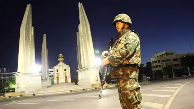 ทหารยืนประจำการบริเวณอนุสาวรีย์ประชาธิปไตยในคืนวันที่ 22 พ.ค. 2557 หลัง พล.อ.ประยุทธ์ จันทร์โอชา ผบ.ทบ. ในขณะนั้น กระทำการรัฐประหารและประกาศเคอร์ฟิวซึ่งมีผลตั้งแต่เวลา 22.00 น. ของวันเดียวกัน