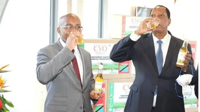 Wasiirka arrimaha dibadda Tanzaniya Paramagamba (Midig ) oo tijaabinaya daawa dhireed laga keenay Madagascar