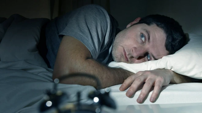 Ọkùnrin tó wà lórí ìbùsùn tí kò rí oorun sùn 