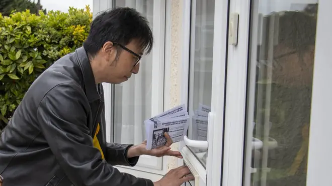 崔天成在選民的信箱留下競選傳單。