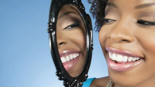 Foto de mujer mirándose al espejo