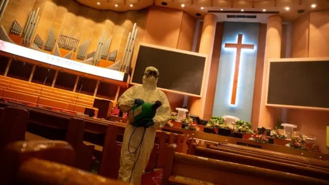 Worker disinfecting a church