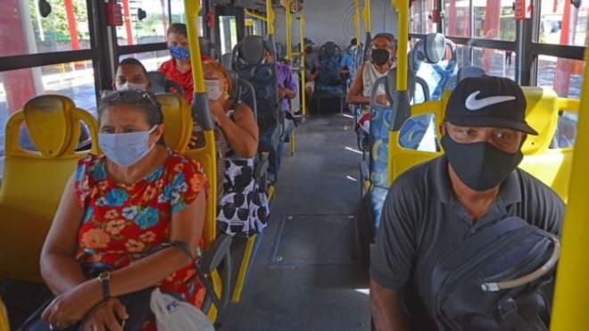 ônibus com passageiros de máscara