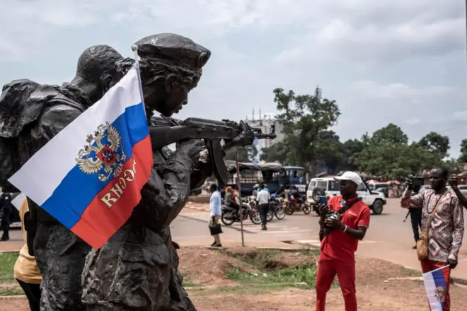Un drapeau russe avec l'emblème de la Russie est accroché au monument des instructeurs russes à Bangui, le 22 mars 2023, lors d'une marche de soutien à la présence de la Russie et de la Chine en République centrafricaine.