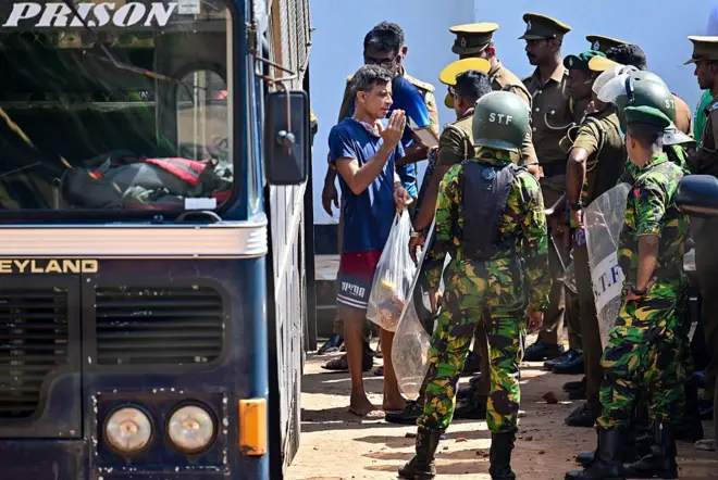 SRI LANKA-PRISON-RIOT Security personnel escort prisoners to a bus at Negombo prison on the outskirts of Colombo on July 6, 2026, following overnight clashes between inmates of two drug gangs. Clashes in a Sri Lankan jail have killed at least 19 people, including four guards, in the worst prison riot in more than five years, officials said on July 6. (Photo by Ishara S. KODIKARA / AFP via Getty Images)