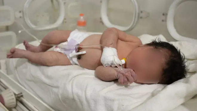 A newborn baby pulled from the rubble of a destroyed building in Jindayris, Syria, receives treatment at a hospital (7 February 2023)