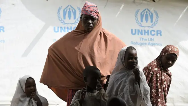 Nigerian refugees wait outside a tent of UNHCR, on April 7, 2015 in the Nigerian refugees camp named 'Dar-es-Salam' near Baga Sola in the Chad lake region.