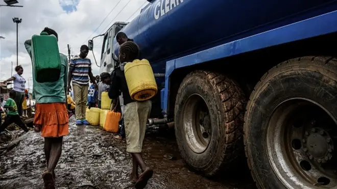 Des enfants kényans transportant des bidons à la recherche d'eau.