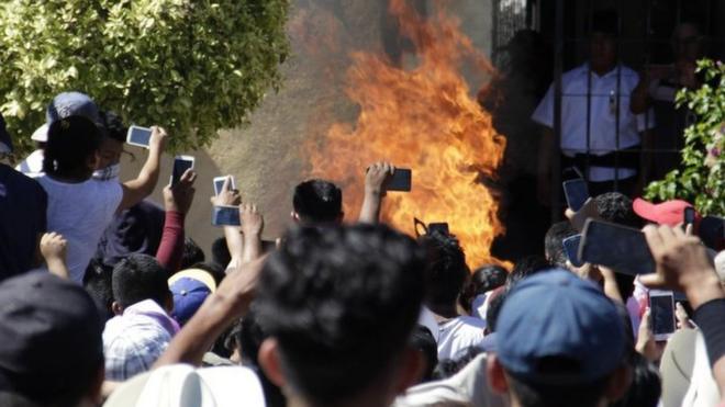 Толпа на мобильные телефоны снимает момент сожжения Рикардо и Альберто