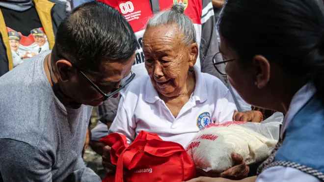 Seorang lansia keluarga dari nelayan menerima bantuan berupa paket sembako saat proses penyaluran di Tambak Mulyo, Semarang, Jawa Tengah, Jumat (9/1/2026). Pemerintah Kota Semarang menyalurkan bantuan sebanyak 400 paket sembako kepada nelayan di wilayah itu sebagai upaya meringankan beban kebutuhan sehari-hari para nelayan dikarenakan tidak bisa melakukan aktivitas melaut dampak dari cuaca ekstrem musim baratan yang mengakibatkan gelombang ombak laut menjadi tinggi.